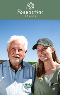 Portrait of two coffee producers standing outdoors, with the Sancoffee logo above.